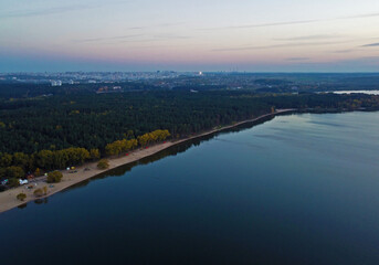 Evening lake shore with forest