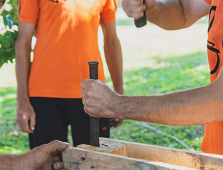 Working with wooden pallets. A man breaks a board in a pallet.