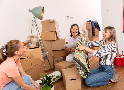 Female Friends Helping Their Girlfriend To Move Into A New Apartment.