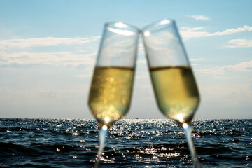 Skyline blue sea and two glasses of wine, focus on the sea. Blurred glasses.
