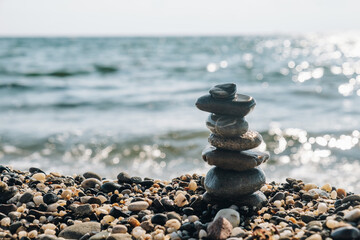 Stones are lined with pillars on the seashore. Pebble balance. Free space on the left.