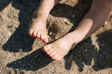 Baby legs with sand at the beach.