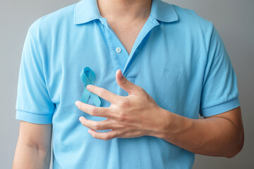 November Prostate Cancer Awareness month, Man in blue shirt with hand holding Blue Ribbon for...