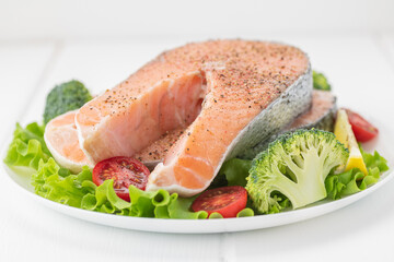 Raw uncooked salmon steak with fresh vegetables.