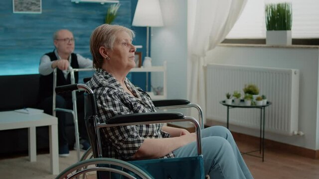 Portrait of elder woman with disability at nursing home. Senior person sitting in wheelchair waiting for assistance and support from caregiver at rehabilitation facility. Invalid pensioner