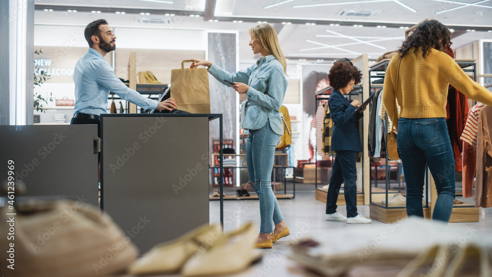 Wall mural customers shopping in modern clothing store, retail sales associate assists client. diverse people i