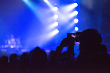 Hand holding smart phone at live music festival