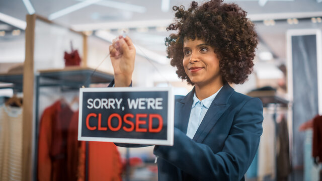 Stylish African American Clothing Shop Manager Changes Fashion Store Sign on the Door to Close. Professional Shop Sales Retail Assistant Working. Small Business Owner at Shopping Mall.