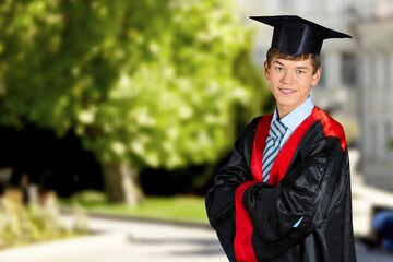 Portrait of handsome male graduate in a graduation robe