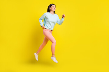 Full length body size view of attractive motivated cheerful girl jumping running isolated over bright yellow color background