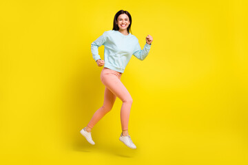 Fototapeta na wymiar Full length body size photo girl jumping high running fast on sale isolated vivid yellow color background