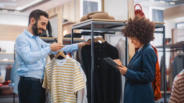 Clothing Store: Businesswoman Uses Tablet Computer, Talks to Visual Merchandising Specialist, Collaborate To Create Stylish Collection. Small Business Fashion Shop Sales Manager Talks to Designer.