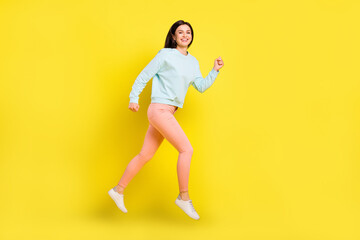 Fototapeta na wymiar Full length body size view of attractive cheerful girl jumping running good mood isolated over bright yellow color background