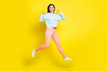 Fototapeta na wymiar Full length body size photo girl jumping high running fast on sale showing thumb-up isolated vivid yellow color background