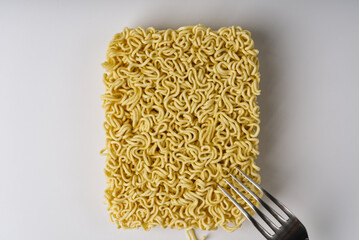 Instant noodles with fork on a white background.