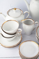 Obraz na płótnie Canvas Porcelain tea set with gold border. Coffee pot, sugar bowl, cups, milk jug, saucers and plates. Service for 6 persons 