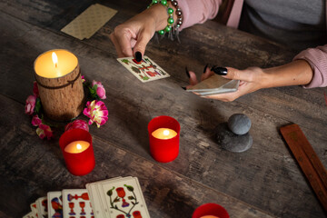 Fortune teller reading a future by tarot cards on rustic table
