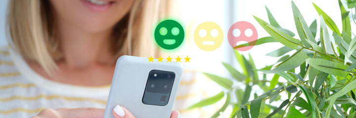 Woman pressing smiley face on mobile phone closeup. Customer evaluation concept