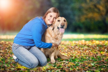 Teenage girl with her cute dog in park