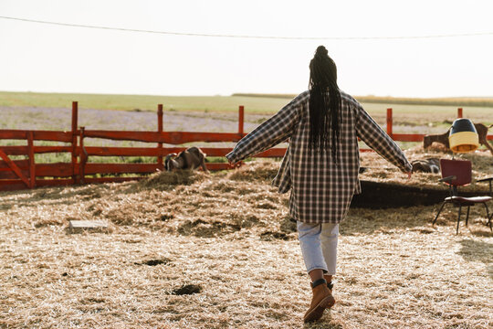 Black Woman In Plaid Shirt Working On Farm Outdoors