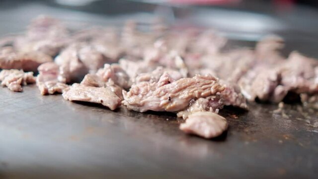 Delicious chopped meat being roasted on a griddle