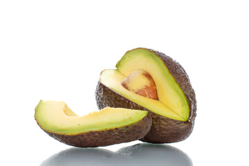 One sliced ripe avocado, close-up, isolated on white.