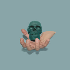 Green skull in the hand. Flying skull. Blue background. 