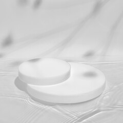 Abstract nature scene with white cylinder podium on transparent water texture with waves, soft shadow of plants on white wall. Pedestal for cosmetic product and packaging mockups display presentation