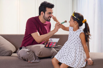 A FATHER AND DAUGHTER HAPPILY PLAYING TOGETHER AT HOME © IndiaPix