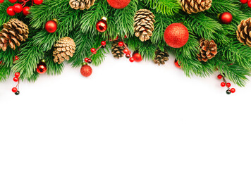 Christmas and New Year background with green spruce branches, cones, balls and red berries, white banner, top view, copy space