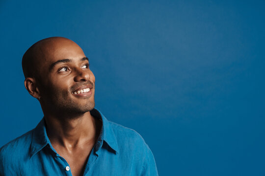 Black Bold Man Wearing Shirt Smiling And Looking Aside