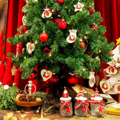 Schöner Tannenbaum feierlich geschmückt zu Weihnachten vor rotem Hintergrund mit Geschenken unter...