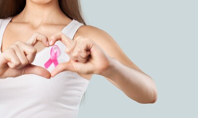 Young woman showing pink ribbon symbolizing breast cancer