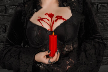 a girl with long hair in the image of a witch is trying to set herself on fire. rituals with...