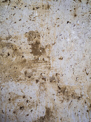textured old gray concrete background stained with beige stucco with scratches and holes.