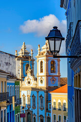 Colorful colonial houses facades and historic church towers in baroque and colonial style with blue...