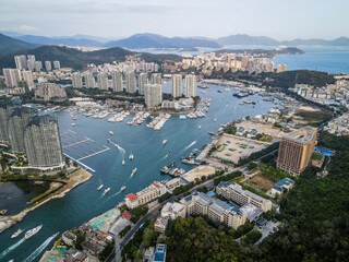 Aerial drone shot cityscape of Sanya city with marina and buildings Hainan tropical island China