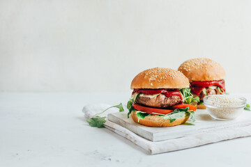 close-up of two burgers on a white background - obrazy, fototapety, plakaty