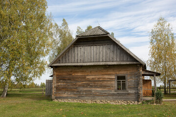 Plakat Abandoned wooden house in a dead village. Golden autumn. Old rustic architecture.