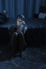 Woman checking her smartphone late at night