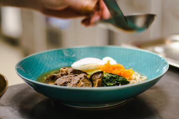 Beef ramen soup with poached egg and vegetables at a restaurant