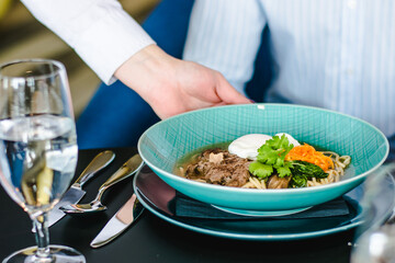 Beef ramen soup with poached egg and vegetables at a restaurant