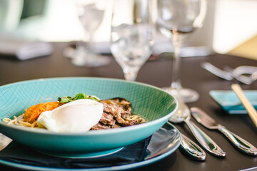 Beef ramen soup with poached egg and vegetables at a restaurant