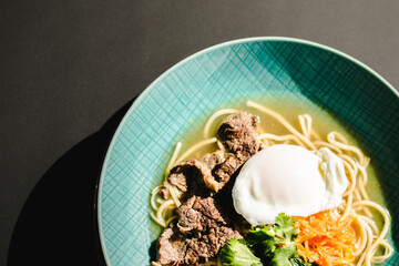 Beef ramen soup with poached egg and vegetables at a restaurant