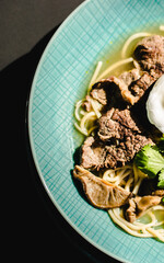 Beef ramen soup with poached egg and vegetables at a restaurant