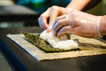 Sushi chef making maki and sashimi sushi at a sushi restaurant