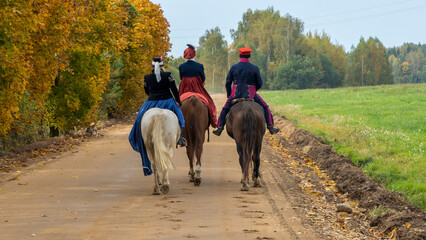 Group of fox hunters on the horses in the autumn field. Reconsruction of traditional horse hunting.