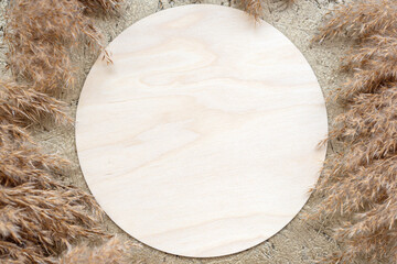 Wooden empty round sign template with copy space and fall decor of dried fluffy reeds pampas grass...