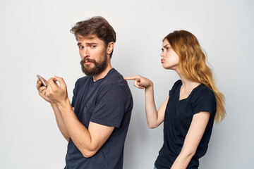 cheerful young couple in black t-shirts phone fun together friendship Studio Lifestyle