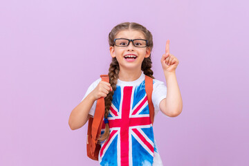A schoolgirl with an image of the English flag on a T-shirt with glasses points her finger at the...